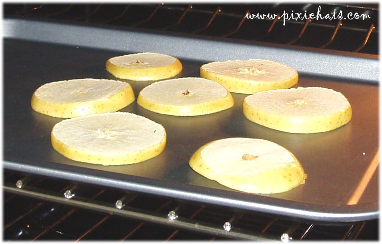 Drying out apple slices in the oven to make the yule garland